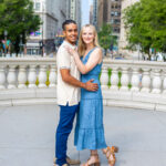 man in white shirt holding woman in blue dress in millennium park at engagement photoshoot